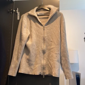 Beige ribbad tröja från Ljung by Marcus Larsson - Säljer en stilren beige ribbad tröja från Ljung by Marcus Larsson. Tröjan har en dragkedja framtill och långa ärmar, perfekt för en avslappnad look. Passar bra till jeans eller chinos. Perfekt för vår och höst! Den är nästan aldrig använd och har en mycket bra passform! Säljer för ett billigt pris 🏆 