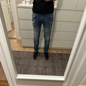 Blå replay jeans med slitningar - Blåa replay anbass jeans med slitningar, storlek 30x32!
