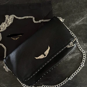 Svart axelväska med silver detaljer  - aldrig använd 26 x 14 cm. ej äkta därav priset, skicka meddelande ifall du vill ha bilder på den bredvid den äkta 💕