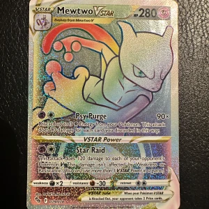 Mewtwo VSTAR Pokémonkort - Säljer ett holografiskt Mewtwo VSTAR-kort från Pokémon TCG med 280 HP. Kortet har färgglad design med Mewtwo i fokus och attacker som Psy Purge och Star Raid. Perfekt för samlare eller spelare som vill stärka sin lek.