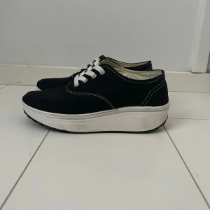 Svarta sneakers med vit platåsula - Sko med rundad sula som är bra och ger mer stöd för foten. Fint skick, bara använda ett fåtal gånger. Storlek 37.