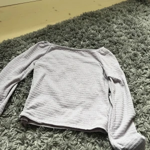 Ljuslila långärmad topp från Kappahl - Säljer en ljuslila långärmad topp från Kappahl. Tröjan har en ribbad struktur och är i ett mjukt, stretchigt material. Perfekt för dig som gillar enkla och stilrena plagg med en twist.