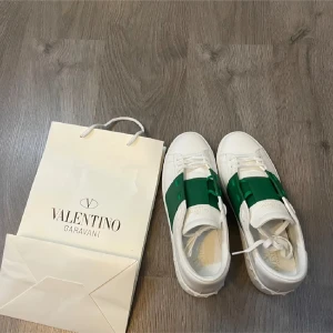 Valentino Garavani Open sneakers med grön detalj - Säljer ett par vita Valentino mycket lite använda. Små i storleken därav försäljning.