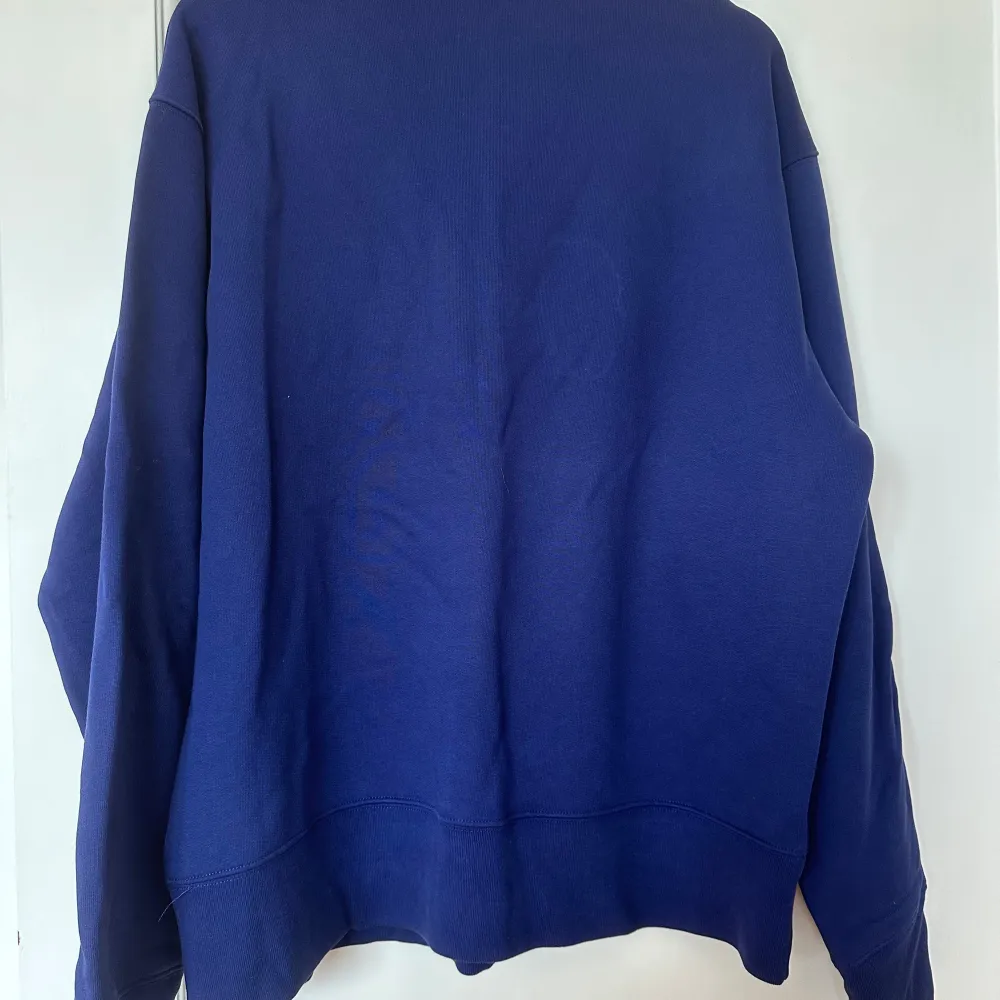 Säljer en stilren blå sweatshirt från Acne Studios med rund halsringning och diskret logotyp på bröstet. Tröjan har en relaxed passform och långa ärmar. Perfekt för en enkel och clean look.. Neuletakit & Villapaidat.