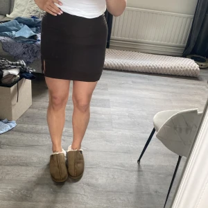 Mörkbrun tight kjol med slits - Snygg svart tight kjol med en liten slits på sidan. 