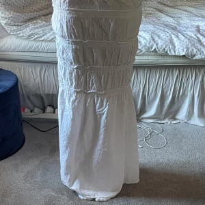 Vit långkjol med volangdetaljer - Supersöt vit långkjol med flera volangpartier och broderade detaljer. Säljer då den tyvärr är för kort för mig nu💞💞