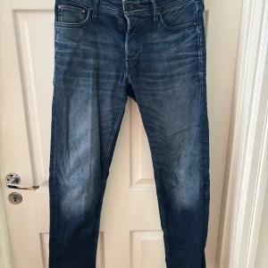 Mörkblå jeans från Jack & Jones  - Snygga mörkblå jeans med. Klassisk femficksmodell med smal passform och raka ben. Perfekta för dig som gillar en stilren look med lite edge. Jeansen har normal midja och är.