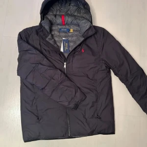Svart jacka från Polo Ralph Lauren - Säljer en snygg svart jacka från Polo Ralph Lauren i bra skick. Perfekt för höst och vinter. Strl M. Tag i ingår ej.  Kan gå ner i pris vid snabb affär!