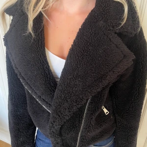 Svart teddyjacka med dragkedjor - Mysig och varm svart teddyjacka. Den går att dra upp hela vägen. 
