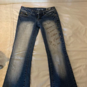 Crazy age vintage jeans - Snygga blå bootcut jeans från Crazy  textdetaljer på vänster lår. Är 36 men mer åt XS så XS/S. Pris kan diskuteras 