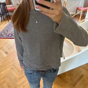 Grå ribbad tröja från H&M - Snygg grå ribbad tröja från H&M. Använd max två gånger men har legat nertryckt i min garderob och den är därför lite knöglig på bilderna men jag stryker såklart tröjan innan leverans!! Perfekt till hösten och vintern till tex ett par jeans🥰🥰