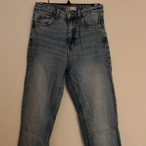Ljusblå jeans high waist - Jeans i ljusblå tvätt med raka ben och hög midja. Jeansen har slitts i benslutet. Något långa för mig som är 170cm.