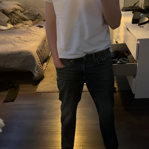 Blå straight fit jeans från H&M - Säljer ett par blå jeans från H&M i straight fit med regular passform. Jeansen har klassisk femficksdesign, normal midja och snygga slitningar framtill. Perfekta för dig som gillar en enkel och tidlös look.