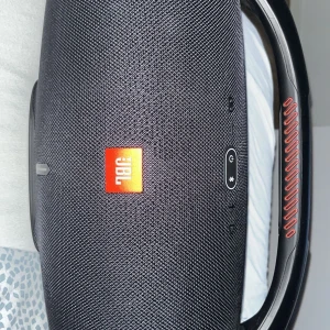 JBL Boom Box 2 (ingen box) - Bilderna visar en JBL Boombox 2, en kraftfull bärbar högtalare perfekt för fester och musikupplevelser. Den har robust design, tydliga kontroller och ett stort handtag för enkel transport. Passar dig som vill ha grymt ljud och ta med musiken överallt. Riktig bra högtalare köpte den föra året super bra ljud inget fel me den bara att det finns ingen box för den. ( pris kan diskuteras)