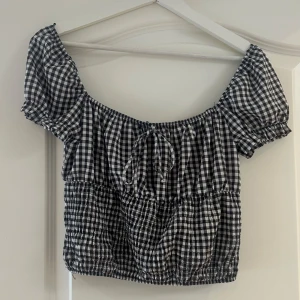 Svartvit rutig blus från Bershka - Supersöt blus från Bershka med svartvitt rutigt mönster, puffiga korta ärmar och knyt framtill. pris går att diskutera, hör av er vid frågor!💗