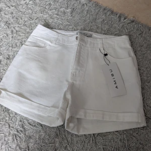 Vita jeansshorts - Fräscha vita jeansshorts med klassisk femficksdesign och uppvikta benslut. Shortsen har knapp och dragkedja framtill samt en clean look som passar till många stilar. Perfekta för varma dagar och enkel att matcha med favorit-tishan.
