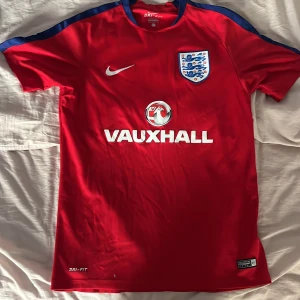 England röd Nike fotbollströja M - Säljer en röd England fotbollströja från Nike med Dri-Fit material i 100% polyester.