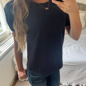 Marinblå blus med puffärm - Mörkblå blus med rund halsringning och gulliga puffärmar. Perfekt för att fixa till sig lite extra eller för att piffa upp en ”basic” outfit.