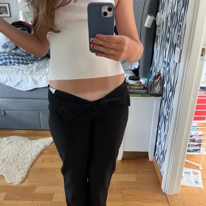 Svarta raka kostymbyxor - Säljer ett par svarta kostymbyxor med rak passform. Byxorna har klassisk knapp och dragkedja framtill, och är tillverkade i ett mjukt bomullsmaterial. Snyggt snitt som ger en chill och trendig vibe, perfekta till crop tops eller linnen. Knappt använda💕