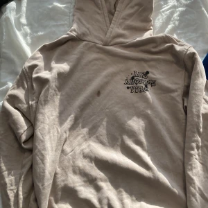 Beige hoodie Los Angeles Vibe - Säljer en beige hoodie från Denim Day med coolt graffiti-tryck 'Los Angeles Vibe' i svart, lila, orange och grönt på både bröstet och ryggen. Tröjan har huva och långa ärmar, perfekt för dig som gillar streetstyle och vill sticka ut. Hoodien har ett litet fläck ( se första bilden) det går säker och få bort.