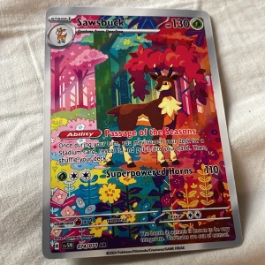 Sawsbuck - Upptäck den färgsprakande Pokémon-kortet Sawsbuck! Med coola attacker och en magisk höstskogsdesign är detta ett måste för samlare och fans. Perfekt för dig som älskar Pokémon och vill ha något unikt i din samling.
