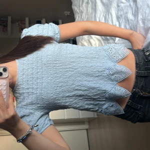 Ljusblå blus med spetsdetaljer - Supersöt ljusblå blus med puffiga korta ärmar och vågig struktur. Blusen har många detaljer vilket jag tycker är väldigt snyggt. Skriv för fler bilder eller eventuella frågor!!🩵🩵