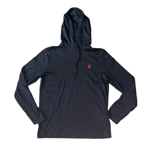 Ralph Lauren hoodie - Svart hoodie från Polo Ralph Lauren med röd broderad logga på bröstet. Tröjan har huva med snörning och långa ärmar. Tillverkad i mjuk bomull som känns skön mot huden. Passar dig som gillar stilren och enkel design med en touch av klassisk streetwear. Hoodien är lika tjock som en T-shirt 