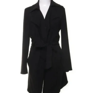 Svart mocka trenchcoat från Amisu - Svart trenchcoat från Amisu i mjuk mocka-look. Jackan har långa ärmar, klassisk krage och knytskärp i midjan för en snygg siluett. Perfekt för dig som gillar stilrena och tidlösa plagg med en modern touch.