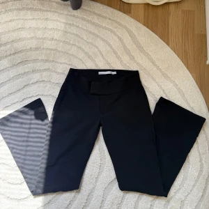 Svarta lågmidjade byxor  - Svarta byxor från  lager 157 i bootcut-modell med bred resår i midjan. Har bootcut ben och stretchigt material. Är endast använda en gång