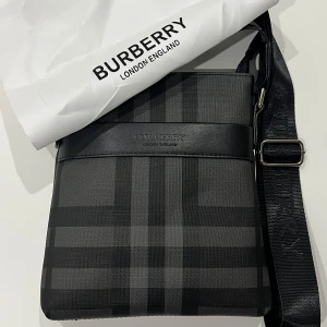 Burberry AxelVäska - Burberry axelremsväska i nyskick Stilren väska med justerbar axelrem och dragkedja. Använd ett fåtal gånger, mycket hög kvalitet. Tre innerfickor och en ytterficka. Vit Burberry-väska medföljer.    Dm om intresse ✅