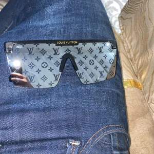 Louis Vuitton svarta monogram solglasögon - Säljer ett par svarta Louis Vuitton solglasögon med spegellinser och ikoniskt LV-monogram över hela glaset. 