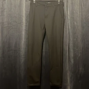 Svarta kostymbyxor/chinos från Smog  - Svarta kostymbyxor från Smog i storlek XS. Byxorna har klassisk rak passform med sidofickor och hällor för bälte. Materialet är en mix av polyester, viskos och elastan som ger en mjuk och stretchig känsla. Perfekta för en clean och stilren look.