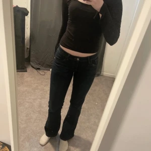 Lågmidjade jeans - Säljer ett par mörkblå jeans från H&M Divided. De har en klassisk femficksdesign och en bootcut-stil som ger en snygg siluett. Perfekta för en avslappnad look. Jag ä 173 som referens 