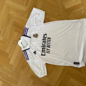 Real Madrid tröja - Säljer en Real Madrid tröja från 22/23 säsongen. Den är i mycket bra skick och säljs för väldigt bra pris. Benzema på ryggen.