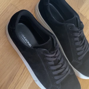 Svarta sneakers från Vagabond - Snygga svarta sneakers från Vagabond med vit sula. Skorna har en klassisk design med snörning och är tillverkade i mocka. Perfekta för en stilren look. Size 43  Helt nya har bara använt de 6 gånger 
