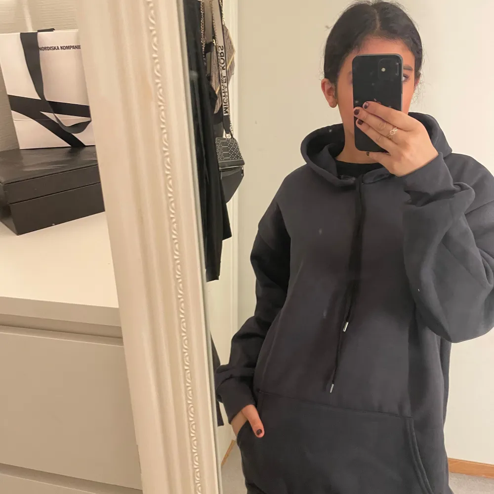 Säljer en blå lång hoodie med en bekväm och avslappnad passform. Den har en klassisk design med dragsko i huvan och en stor ficka framtill. Perfekt för en casual look.. Hupparit & Collegepaidat.