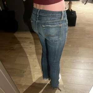 Blå bootcut jeans - Snygga blå bootcut jeans med orange detaljer på baksidan 