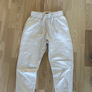 Vita mjukisbyxor med snörning - Säljer ett par bekväma vita mjukisbyxor med snörning i midjan. Perfekta för en avslappnad stil. Byxorna har en normal passform och är tillverkade i mjukt material.