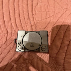 PlayStation Berlock - Jag använder inte den, så jag tänkte sälja den istället. Det är PS1 modellen, tycker att den är cool. Köpt för ett tag sen, på GameStop eller Webhallen. 4,5cm på bredden och 6,5cm i längden. Pris: 30kr
