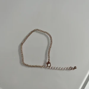 Guldfärgat armband med justerbar kedja - Snyggt guldfärgat armband med en justerbar kedja och karbinhake. Perfekt för att ge en elegant touch till din stil. Enkel design som passar till många olika outfits. Oanvänd från Ur&penn, färg har släppts på klolåset men inget man tänker på. 