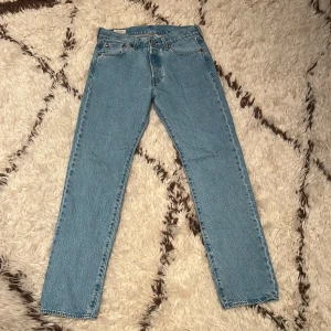 Levis 501 jeans i ljusblå denim - Säljer ett par klassiska Levis 501 jeans i ljusblå denim. De har en rak passform och är midwaist. Perfekta för en avslappnad stil. Nypris 1200:- Jag säljer för 600:- använda 1 gång.