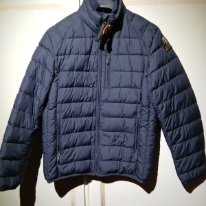  Äkta Mörkblå dunjacka från Parajumper - Säljer en snygg mörkblå dunjacka från Parajumpers. Jackan har en quiltad design med dragkedja framtill och en cool patch på ärmen. Perfekt för kyliga dagar med sin superlätta vikt. 🧥