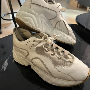 Vita sneakers från Acne Studios Rockaway, Manhattan - Vita sneakers i läder från Acne Studios i populära modellen Rockaway / Manhattan Endast använda vid ett par tillfällen och därav i bra skick. Storlek: 41 men är stora så motsvarar 42 Nypris cirka 4 500kr Kommer från ett rök-och djurfritt hem!  Riktigt fina, finns vid Mariatorget. 800:- eller högstbjudande 