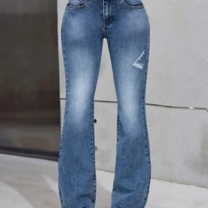 Blå bootcut jeans - Snygga blå bootcut jeans med låg midja från Shein, lätt sliten detalj. Perfekta för en avslappnad stil. De har en klassisk femficksdesign och en bekväm passform.  Oanvänd, säljes då dom var för korta i längden.