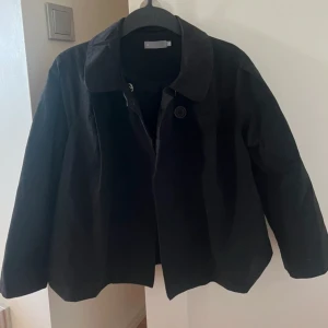 Svart jacka  - Så fin och cool svart tunn jacka som man kan knäppa upptill med två fina knappar. I ett slags jeansmaterial. Storlek 40 men passar mig som vanligtvis bär xs/s beroende på hur man vill att den ska sitta.