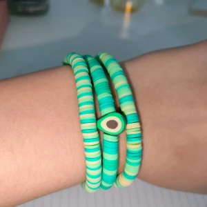 Färgglada armband med avokado-berlock - Säljer ett set med färgglada armband i gröna och gula toner. Ett av armbanden har en söt avokado-berlock. Perfekt för att liva upp din outfit!