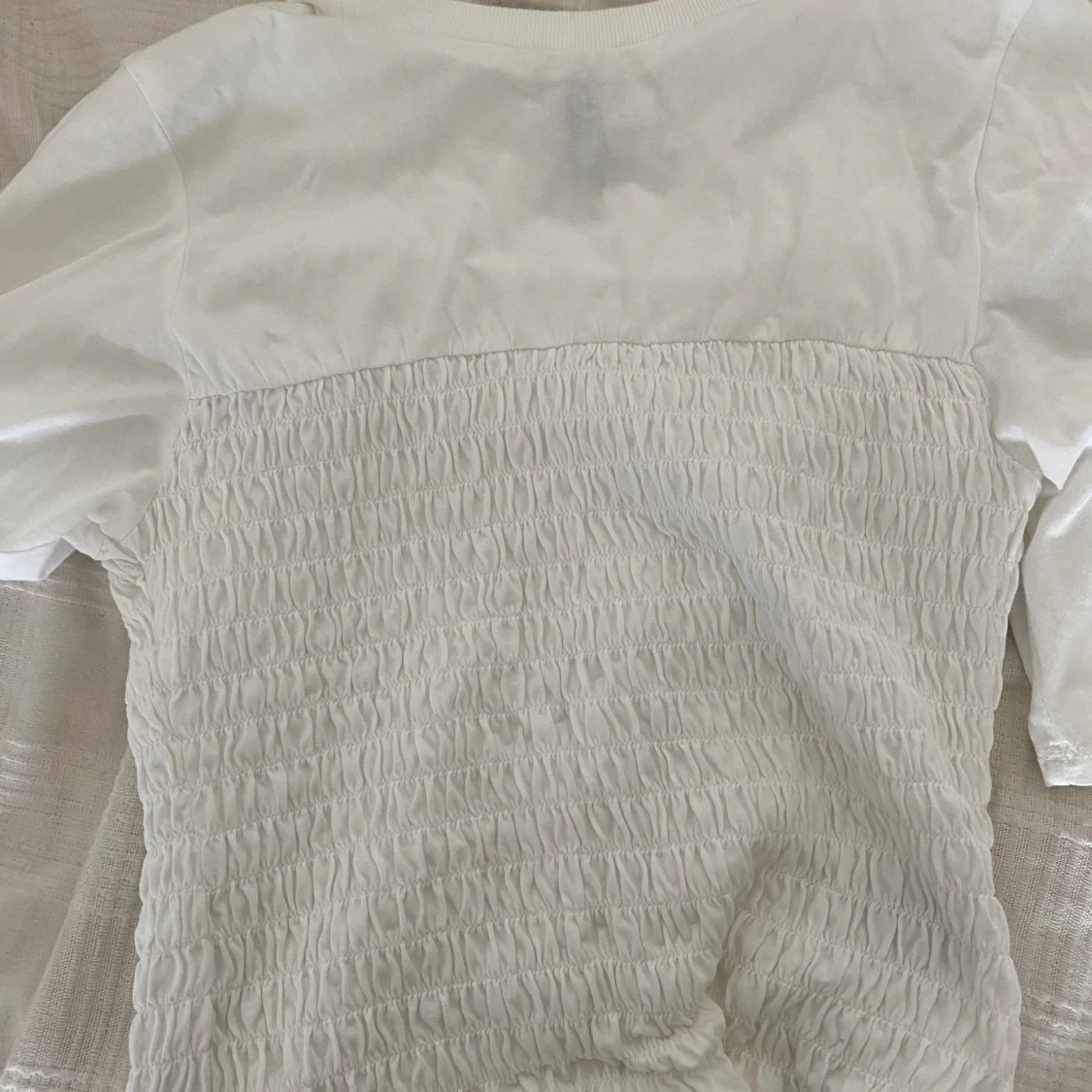 Vit topp med smockdetaljer