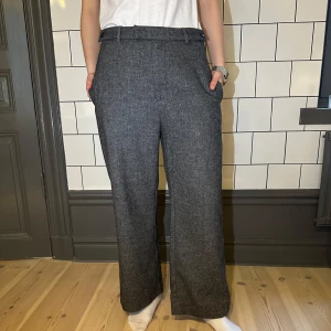 Grå kostymbyxor fr. HOPE  - Snygga grå kostymbyxor fr. HOPE med rak passform. Byxorna har en klassisk design med bälteshällor och sidfickor. Perfekta för en stilren look.