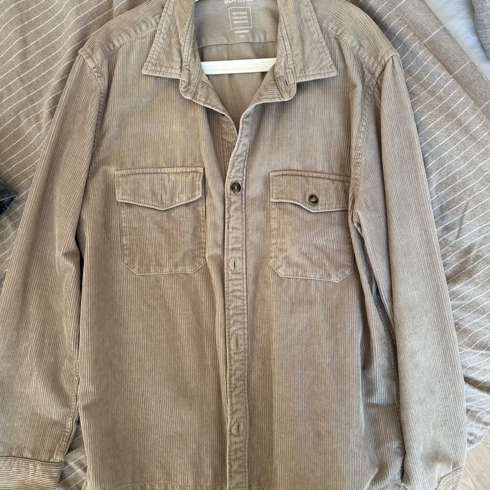 Snygg beige overshirt från Marc O'Polo i manchester. Skjortan har långa ärmar och två bröstfickor med knappar.. Paidat.