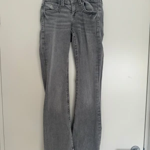 Grå jeans från Gina Tricot - Snygga grå jeans från Gina Tricot med en klassisk femficksdesign. De har en rak passform och är perfekta för en avslappnad stil. Jeansen har en diskret tvättad look som ger dem en cool touch.